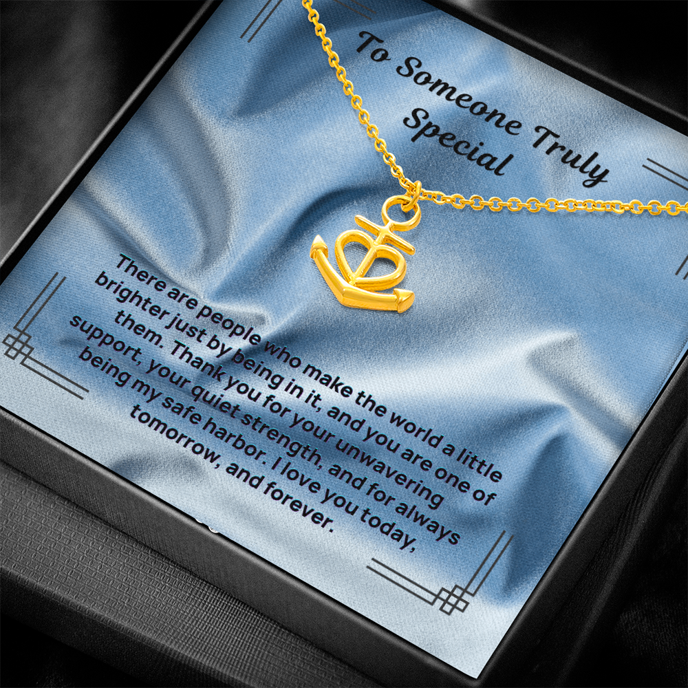 Gold anchor-and-heart pendant necklace on a chain, presented in a gift box.