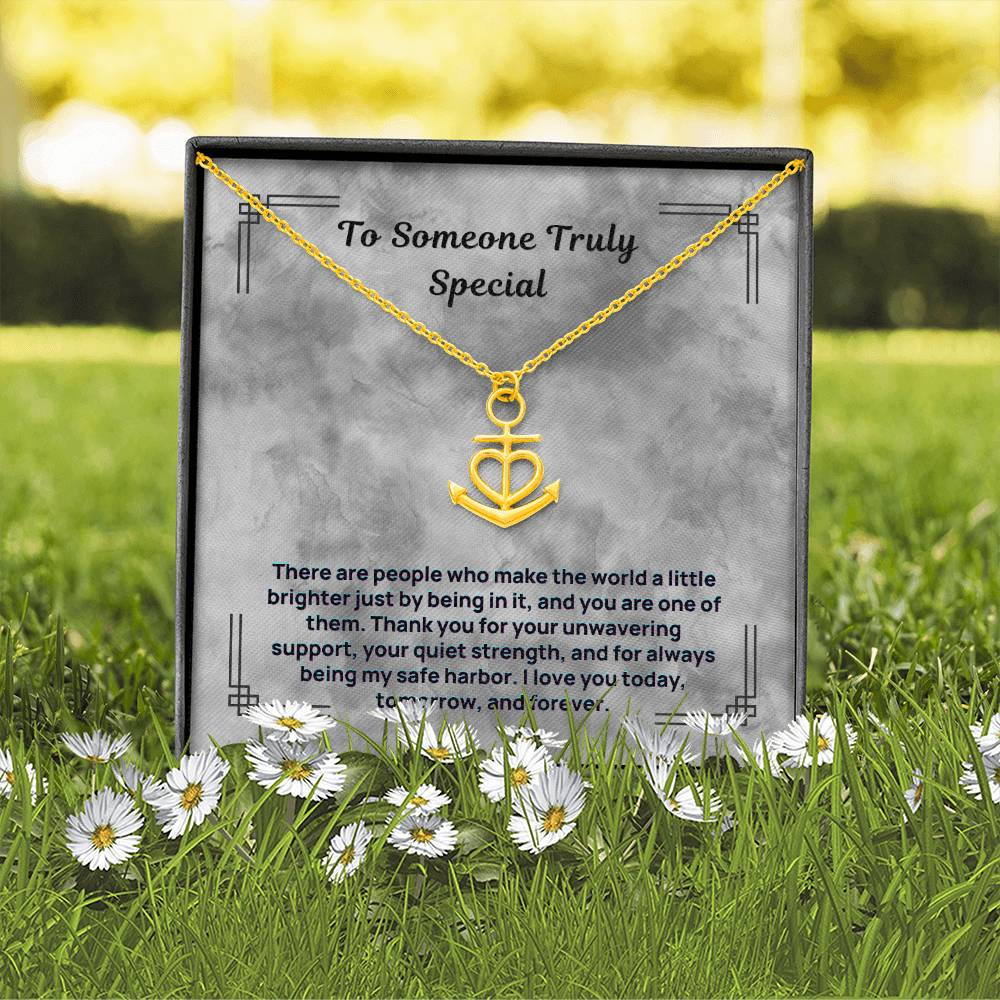 Gold-tone anchor and heart pendant necklace on a gift card