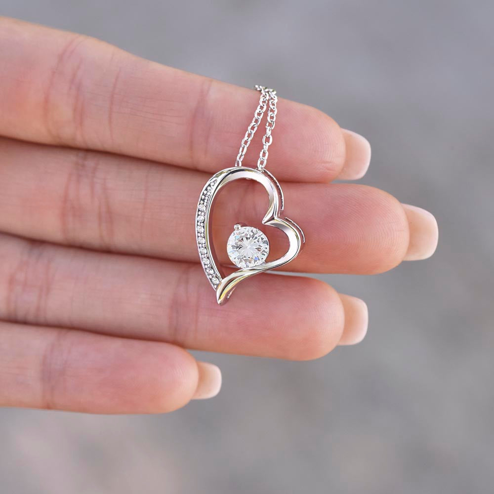 Silver heart pendant necklace with round crystal centerpiece and dangling chain