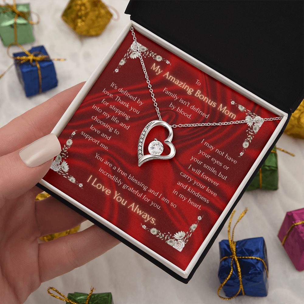 Heart pendant necklace over red floral card in open gift box, silver chain and clasp.