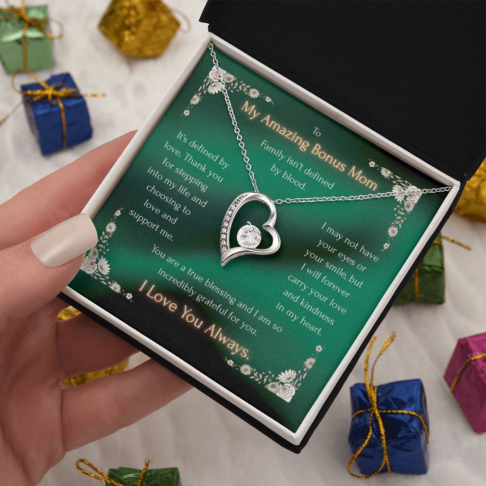 Silver heart pendant necklace with crystal accents, laid across a green gift card