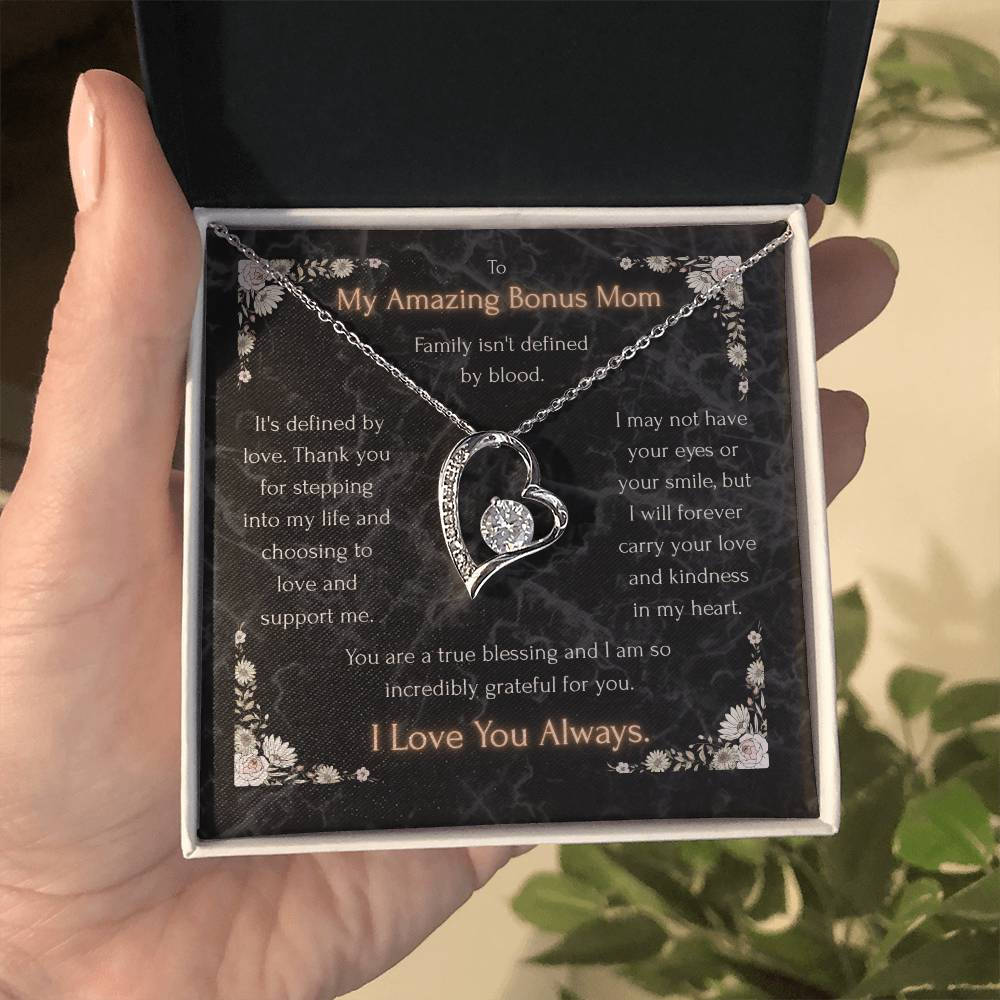Silver heart pendant necklace with clear stone center on a message card in a box