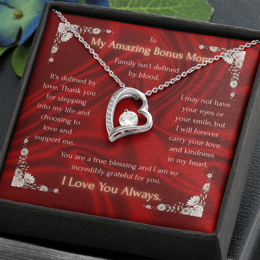 Heart pendant necklace with rhinestone accents on red card inside dark gift box, silver tone.