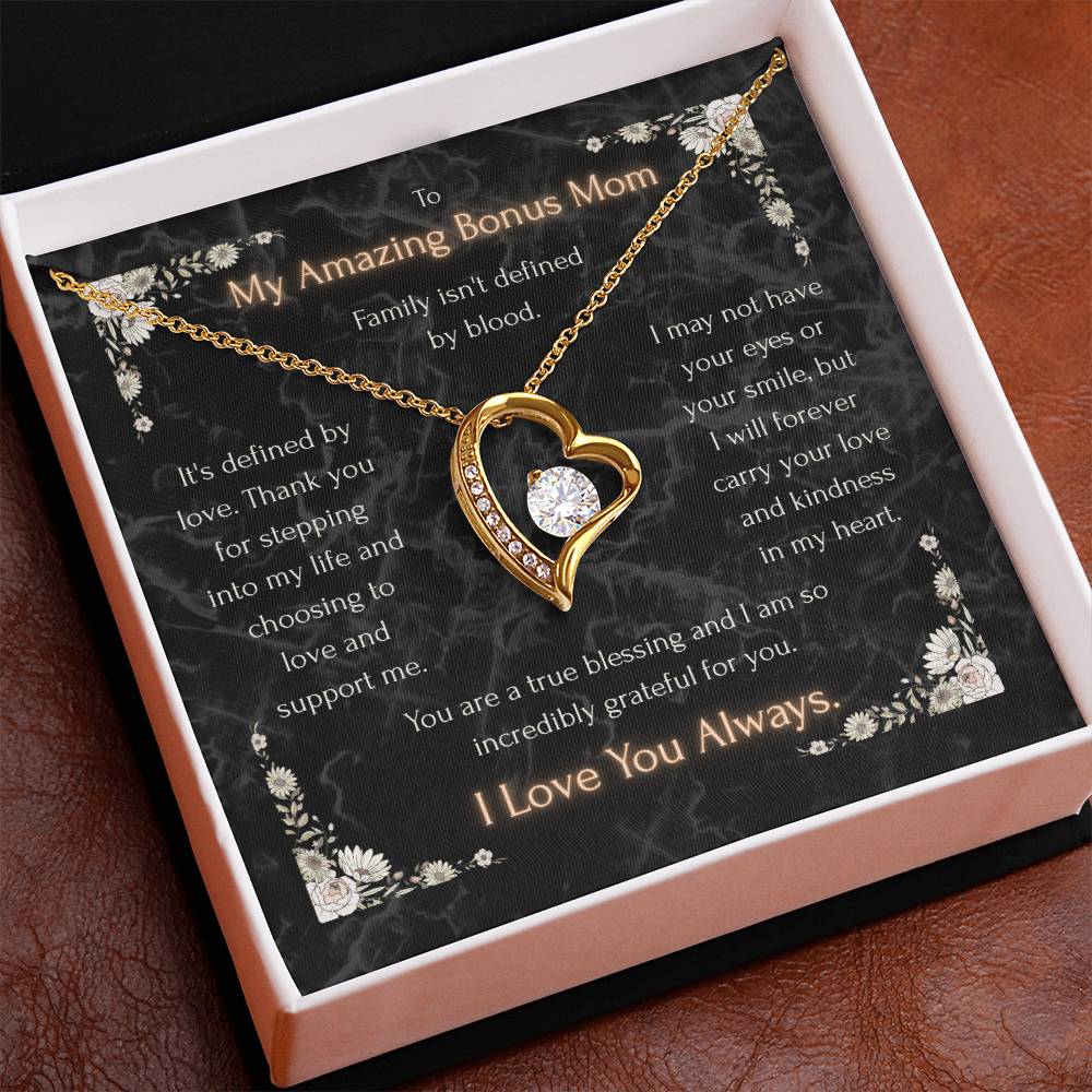 Gold-tone heart pendant necklace with clear center stone and side stones on a chain