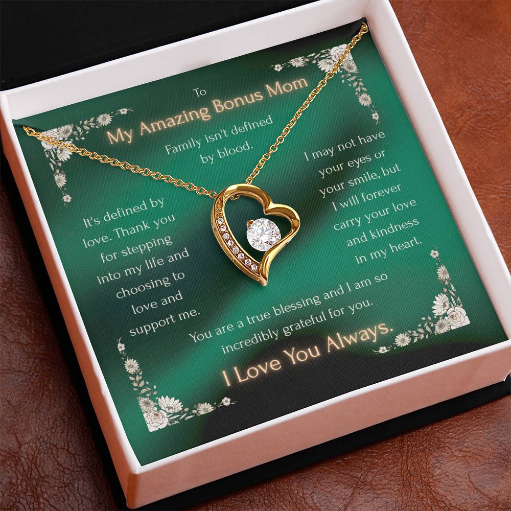Gold-tone heart pendant necklace resting on a green message card inside a gift box