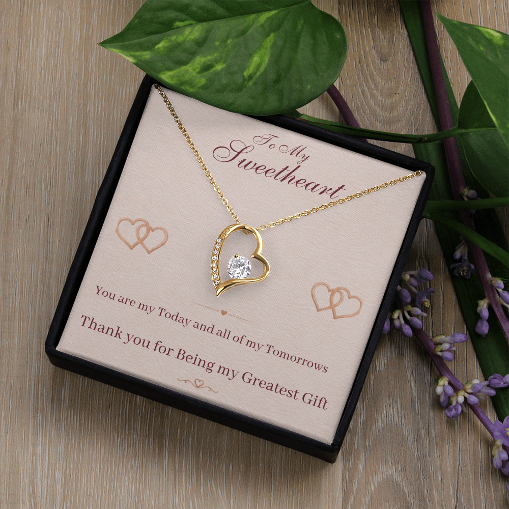 Gold heart pendant necklace with gold chain in open gift box with message card