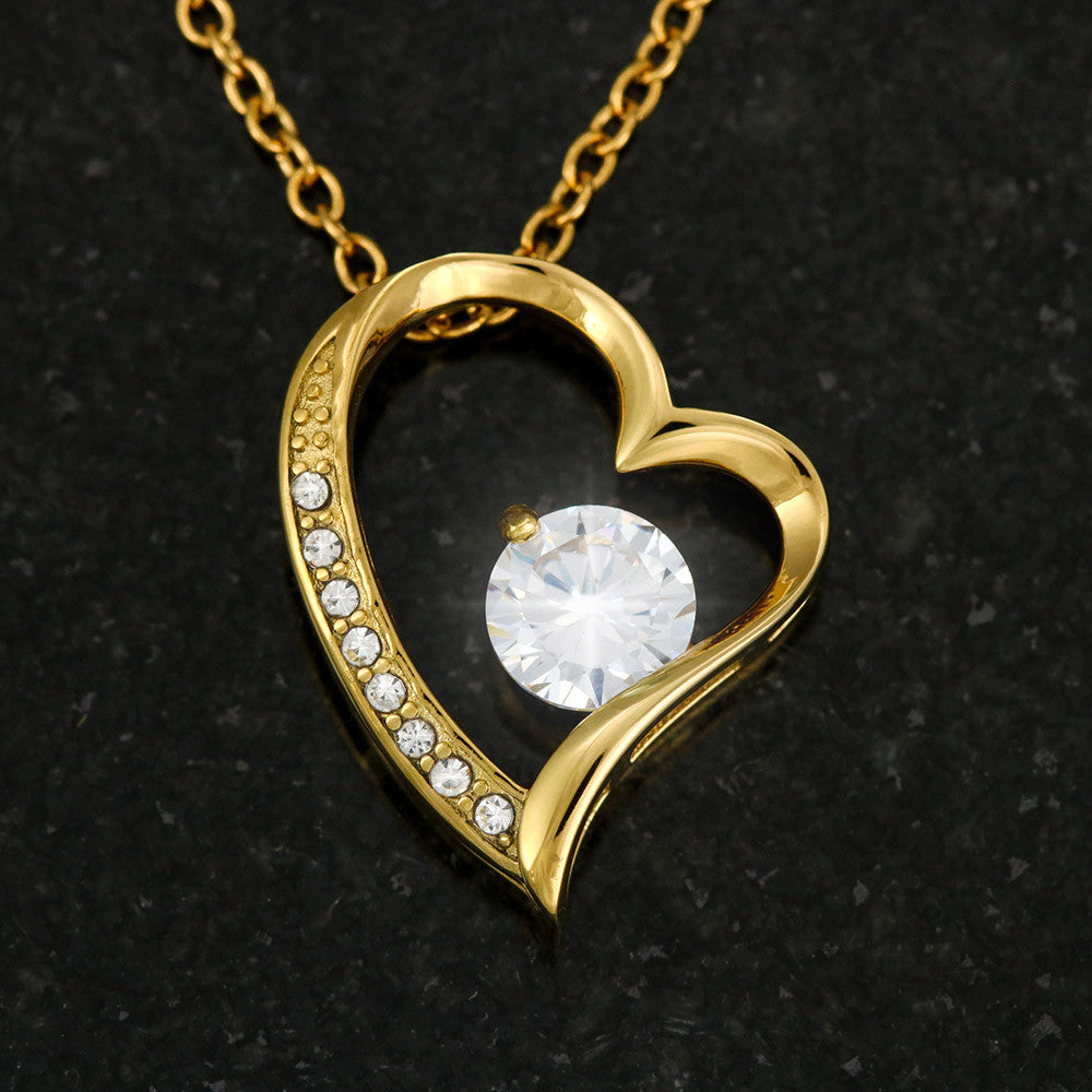 Gold heart pendant necklace with round diamond-like center and side stones