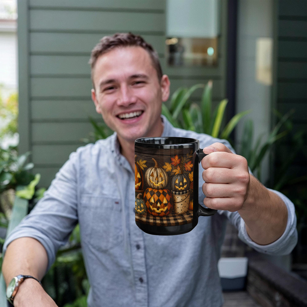 Black ceramic coffee mug with jack-o'-lantern full-wrap print, held in a hand