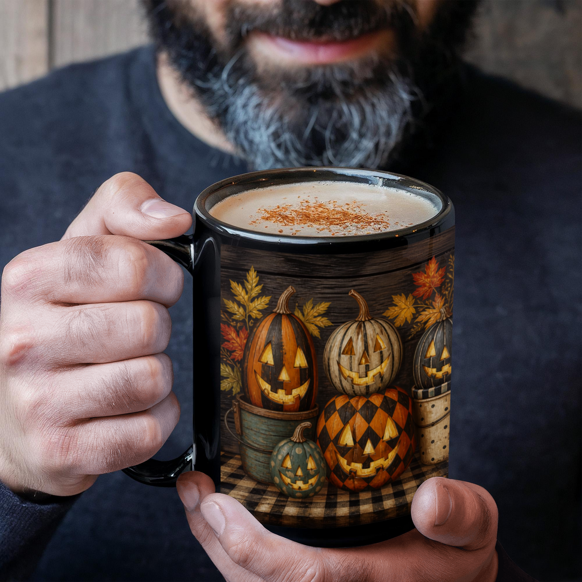 Black ceramic coffee mug with jack-o'-lantern pumpkin design, held near the rim