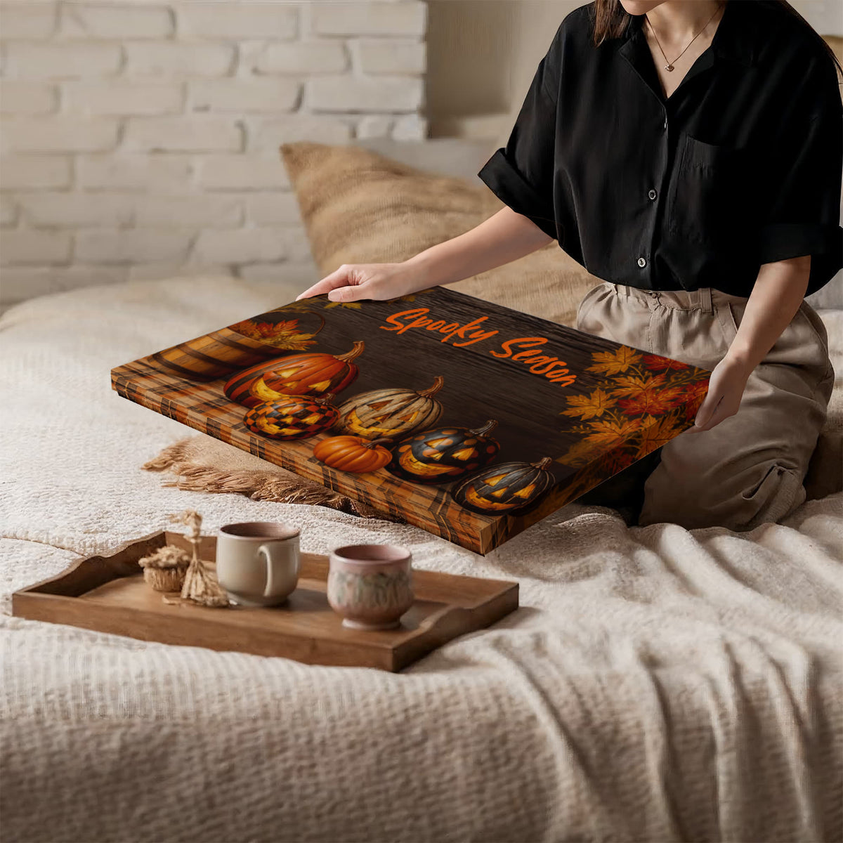 Halloween pumpkin canvas print laid on a bed with orange “Spooky Season” lettering