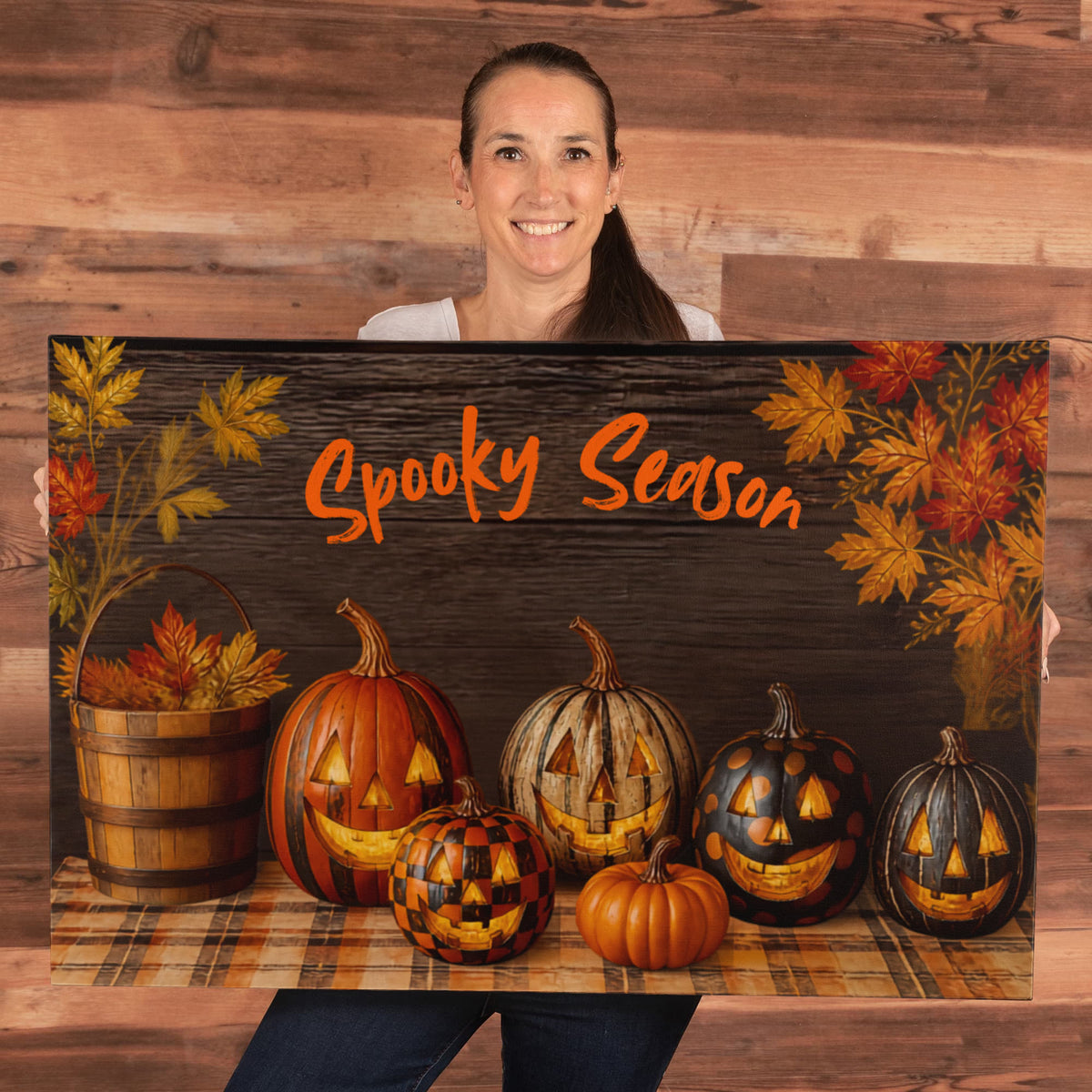 Halloween pumpkin canvas print held up with orange “Spooky Season” text and jack-o’-lanterns
