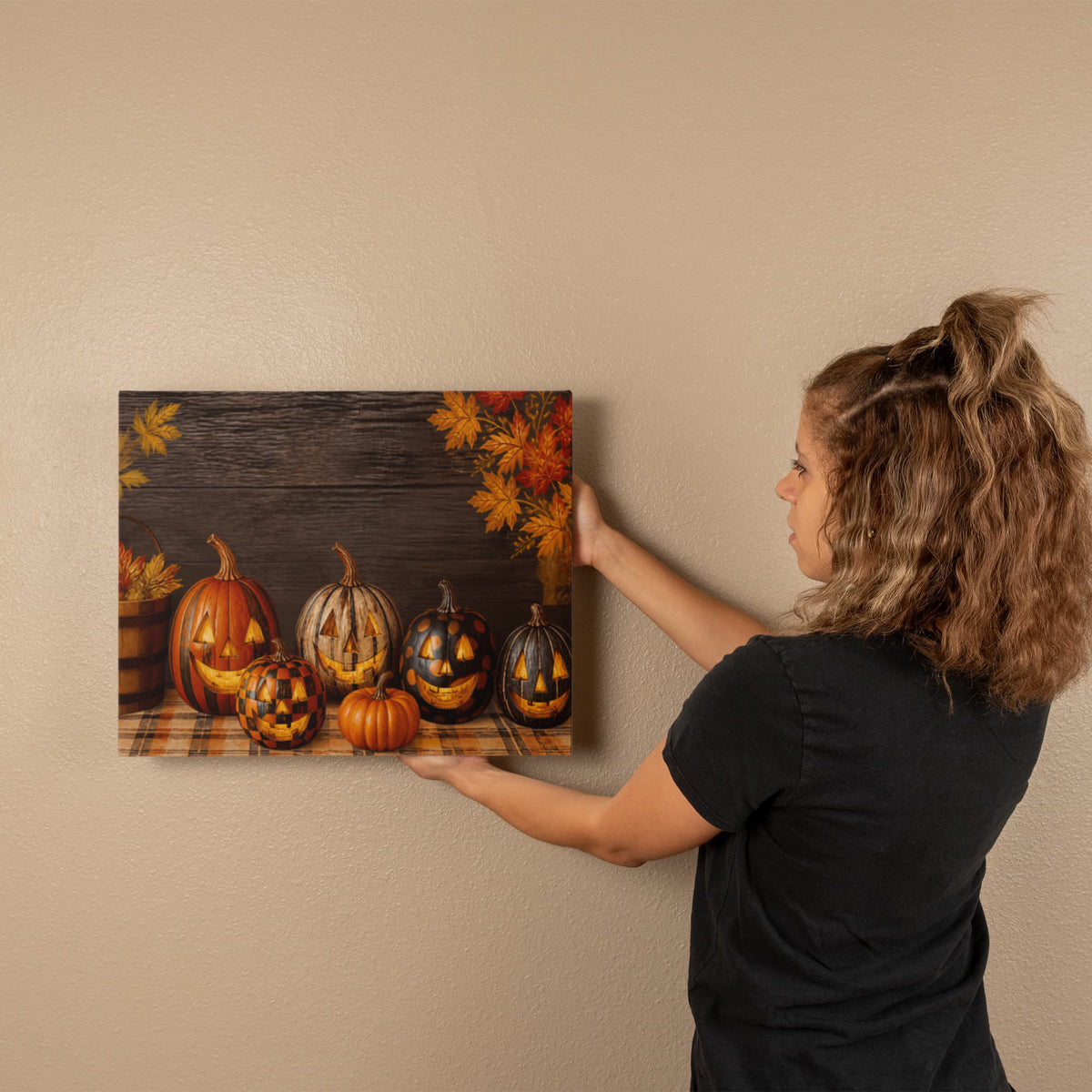 Autumn pumpkin canvas print held against a wall; jack-o’-lanterns and autumn leaves border