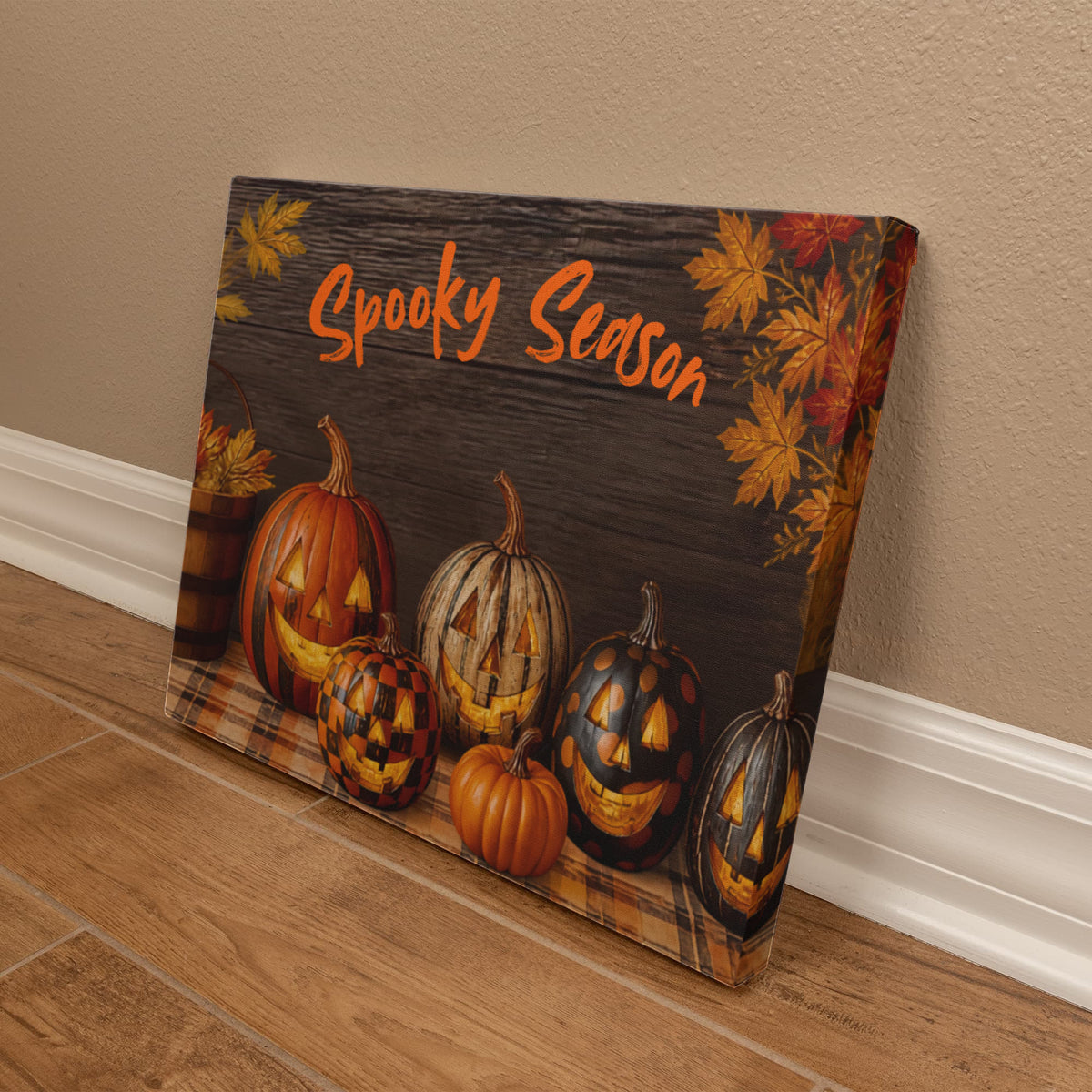 Leaning Halloween pumpkin canvas print with orange “Spooky Season” script and jack-o’-lanterns