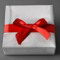 White gift box with red satin ribbon bow