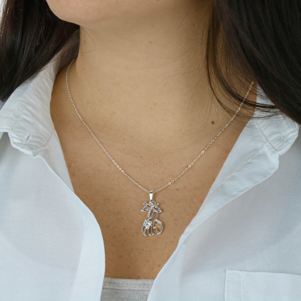 Silver-toned chain necklace with giraffe pendant worn on a white blouse