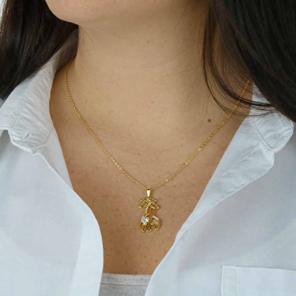 Gold-toned chain necklace with giraffe pendant worn on a white blouse
