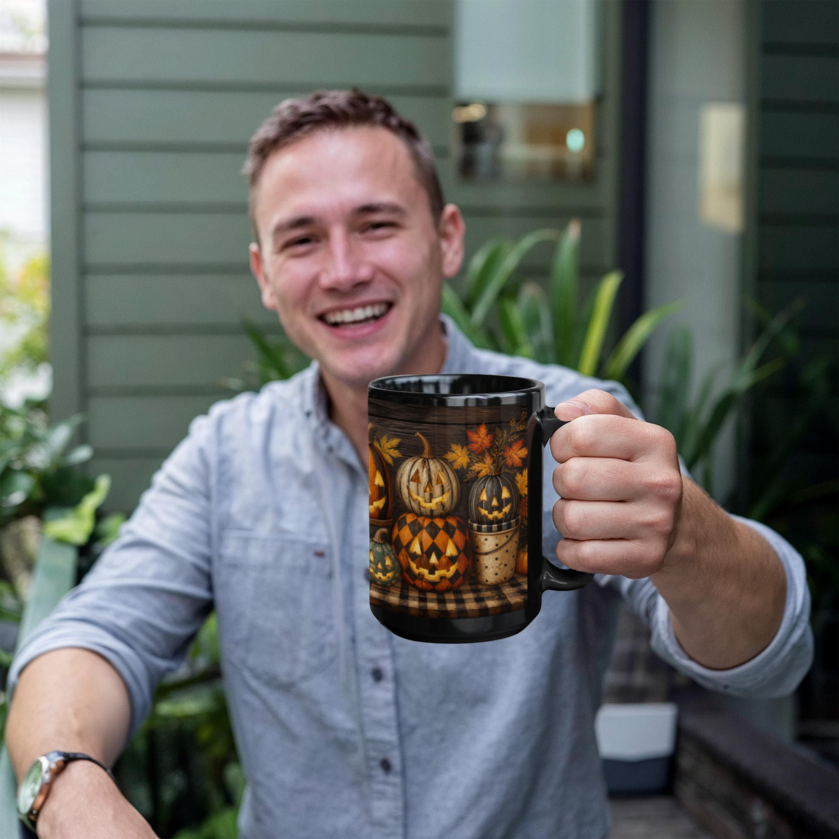 Black ceramic coffee mug with jack-o'-lantern pumpkin graphic, held in a hand